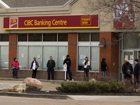 People line up at the CIBC Banking Centre on 118th Avenue on Monday, May 11, 2020, in Edmonton.