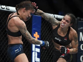 Amanda Nunes (red gloves) fights Germaine de Randamie (blue gloves) during UFC 245 at T-Mobile Arena.