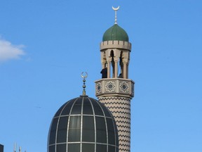 A pair of Muslim men prepare the minaret at the Madinah Masjid mosque in Toronto for the evening Adhan call to prayer just before dusk as part of Ramadan, Sunday, May 3, 2020.