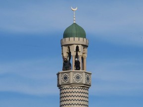 A pair of Muslim men prepare the minaret at the Madinah Masjid mosque on Danforth Ave. for the evening call to prayer just before dusk as part of Ramadan on Sunday May 3, 2020.