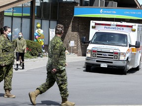 Members of the Canadian Armed Forces walk in front of Pickering's Orchard Villa long-term care home on Wednesday, May 6, 2020.