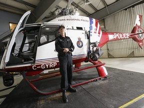 York Regional Police Const. Greg Lubianetzky  in Hangar 17 at Buttonville airport poses with Air2 helicopter on Tuesday August 18, 2015.