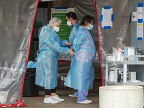Healthcare workers put on protective equipment before entering the Vigi Mount Royal CHSLD senior's residence in Montreal, Quebec, on Friday, May 15, 2020.
