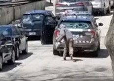 A suspect prepares to toss a rock at a Toronto police officer on Monday, May 4, 2020.