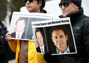 People hold signs calling for China to release Canadian detainees Michael Spavor and Michael Kovrig during an extradition hearing for Huawei Technologies Chief Financial Officer Meng Wanzhou at the B.C. Supreme Court in Vancouver on March 6, 2019. LINDSEY WASSON/ REUTERS