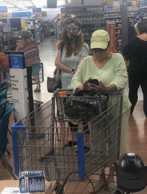 A woman is seen wearing a snorkel and goggles in a Walmart checkout line.