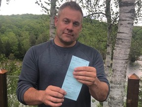 Jason Lake, the owner of the Minden 50’s Diner, holds the ticket he was issued for opening his restaurant to seating.