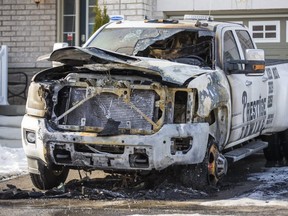 A burned-out tow truck sits in front of a home in Richmond Hill, Ont. last December.  Police have laid numerous organized crime charges in relation to a violent battle between tow truck companies in the Toronto area.