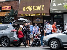 People wearing protective masks enjoy the day during Memorial Day following the outbreak of the coronavirus disease (COVID-19) in the Staten Island borough of New York U.S..