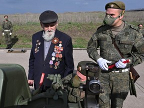 Second World War veteran Ivan Chubov, 94, examines an artillery piece as he attends exercises of artillery crews ahead of the Victory Day celebrations, amid the COVID-19 outbreak, at a range in Rostov Region, Russia, Thursday, May 7, 2020.