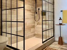 Slick tile, a 'window pane' style shower screen and warm, woodsy accents freshen a formerly lack lustre bathroom. SUPPLIED