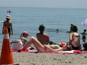 People soak in the sun at Marie Curtis Park in Toronto on Saturday June 20, 2020.