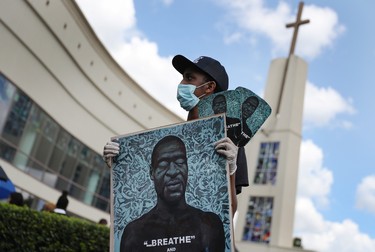 HOUSTON, TEXAS - JUNE 08: Nehemia Tekleab holds a picture of George Floyd during the public viewing at the Fountain of Praise church on June 8, 2020 in Houston, Texas. George Floyd died on May 25th when he was in Minneapolis police custody, sparking nationwide protests.