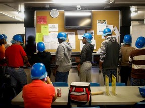 Temporary foreign workers stand in front of job posting board during their lunch break at the Highline Mushrooms farm, Canada's largest mushroom grower, in Leamington, Ont.,  on  April 14, 2016.