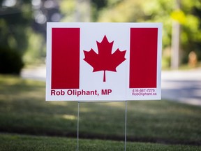 A Canadian flag placard bears the name of Liberal MP Rob Oliphant in a front yard of a home in his Toronto riding.
