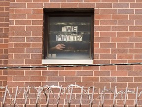 An inmate holds a sign to his cell window reading "We Matter" as Black Lives Matter supporters hold a protest against racial inequality on Father's Day outside Cook County Jail in Chicago, Ill., June 21, 2020.