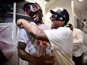 Toronto Raptors forward Kawhi Leonard, left, and teammate Kyle Lowry celebrate defeating the Golden State Warriors and winning the Larry O'Brien NBA Championship Trophy after Game 6 basketball action in Oakland, Calif. on Thursday, June 13, 2019.