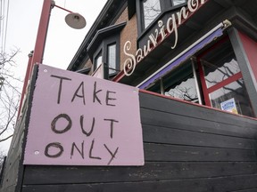 A restaurant in Toronto displays a "Take Out Only" sign on March 18, 2020.