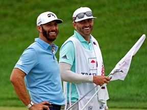 Dustin Johnson celebrates winning the Travelers Championship golf tournament with his caddie Austin Johnson at TPC River Highlands