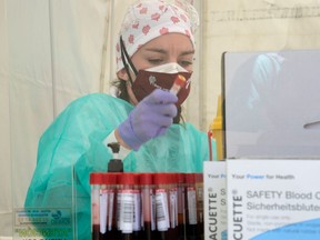 A nurse holds a blood sample at a temporary testing point in Spain.