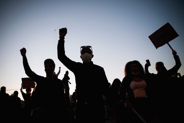 Protestors raise their fists during a Black Lives Matter demonstration in Stockholm, Sweden, on June 3, 2020, in solidarity with protests raging across the United States over the death of George Floyd. - Former Minneapolis police officer Derek Chauvin, who kneeled on the neck of George Floyd who later died, will now be charged with second-degree murder, and his three colleagues will face charges of aiding and abetting second-degree murder, court documents revealed on June 3.
