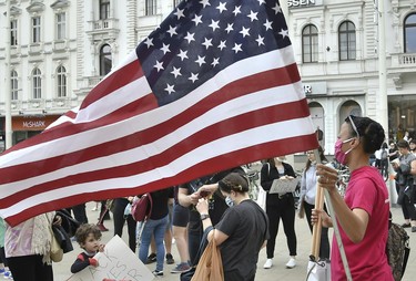 A protestor holds the US flag during a Black Lives Matter march in Vienna, Austria, on June 4, 2020, in solidarity with protests raging across the United States over the death of George Floyd, an unarmed black man who died during an arrest on May 25.