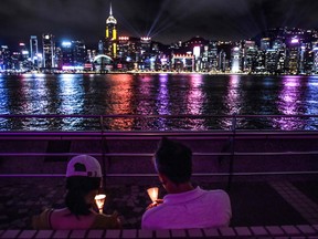 A couple hold candles along the Tsim Sha Tsui waterfront in Hong Kong on June 4, 2020, to mark the 31st anniversary of the 1989 Tiananmen Square crackdown in Beijing.