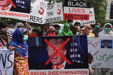 Overseas Pakistani and civil society activists hold placards during a protest against the killing of George Floyd, an unarmed black man who died after a white policeman knelt on his neck during an arrest in the US, in Lahore on June 8, 2020.