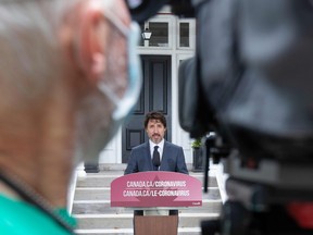 A camera person wears a mask as Canadian Prime Minister Justin Trudeau  speaks during his daily coronavirus briefing at Rideau Cottage in Ottawa, June 25, 2020.