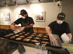 Michael Hunter (left) co-owner of Antler restaurant on Dundas St. W., helps prepare 70 meals -- traditional and veggie -- for staff working through the COVID-19 pandemic at St. Michael's Hospital in April. Hunter said he's not sure reopening his restaurant in a traditional sit-down format will be financially viable.