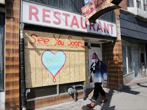 A man wearing a protective face mask passes a boarded up restaurant during the global outbreak of the coronavirus disease (COVID-19) in Toronto, Ontario, Canada April 6, 2020. (REUTERS FILE PHOTO)