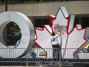 A worker cleans graffiti off the citys iconic Toronto sign in Nathan Phillips Square.