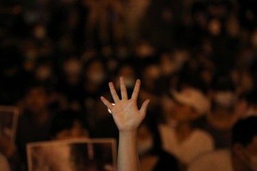 A Hong Kong anti-government protester raises a hand to show support for the five demands at Liberty Square in Taipei to mark the 31st anniversary of the crackdown of pro-democracy protests at Beijing's Tiananmen Square in 1989, Taiwan, June 4, 2020.
