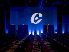 A man is silhouetted walking past a Conservative Party logo before the opening of the Party's national convention in Halifax on Thursday, August 23, 2018.