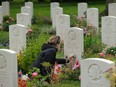 Lise Belanger, 18, cleans the gravestone of her great-uncle, Roger "Sonny" Firman, at the Commonwealth War Graves Commissions Beny-sur-Mer Canadian War Cemetery in Normandy on June 5, 2019 near Reviers, France.