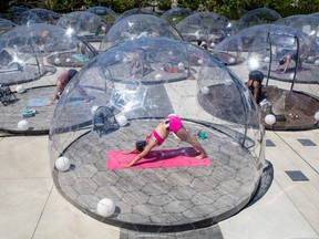 People participate in an outdoor yoga class by LMNTS Outdoor Studio, in a dome to facilitate social distancing and proper protocols to prevent the spread of COVID-19, in Toronto, Sunday, June 21, 2020.