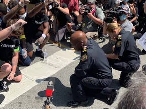 Toronto Police Chief Mark Saunders kneels in front of protesters during the “I Can’t Breathe” anti-racism rally in Toronto on June 5, 2020.