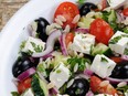 Greek salad orzo pasta with black olive, red onion and cucumber, cherry tomatoes, feta and herbs.