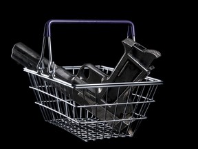 Pistol in a shopping cart. Isolated on black background. With copy space text. Studio Shot.