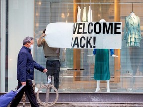 An employee at Zara puts up a sign during a phased reopening from the coronavirus disease (COVID-19) restrictions in Toronto, Ontario, Canada May 19, 2020.