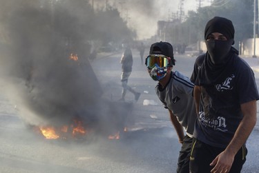 Iraqi demonstrators pose for a photo after burning objects to block the road, amidst concerns about the spread of the coronavirus disease (COVID-19), while they demand the resignation of the governor of Najaf, Lauy al-Yassiri, during a protest in the holy city of Najaf, Iraq June 8, 2020.