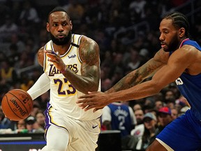Los Angeles Lakers forward LeBron James dribbles the ball as LA Clippers forward Kawhi Leonard defends in the first half at Staples Center in Los Angeles on March 8, 2020.