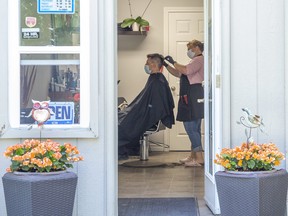 Nikolina Ristic gives a haircut to Srdjan Djukic at her home business, Nikolina Hair Design, in London, Ont. on Friday June 12, 2020.