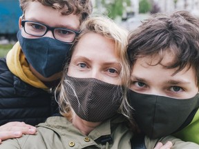 Family selfie with protective face masks on during coronavirus pandemic