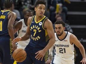 In this Dec. 2, 2019 file photo, Indiana Pacers guard Malcolm Brogdon handles the ball against Memphis Grizzlies guard Tyus Jones during the second half at FedExForum, Memphis, Tenn.