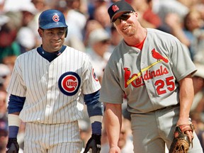 The Chicago Cubs' Sammy Sosa stands with St. Louis Cardinal's first baseman Mark McGwire between pitches after Sosa singled in the second inning on May 28, 1999, at Wrigley Field in Chicago.