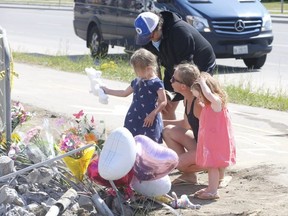 Agatha Kwatserska, her husband Todd Collet and their their daughters Mila, 4 (blue dress), and Sofia 2 (red dress), visit a makeshift memorial on Friday, June 19, 2020, to pay their respects to a mother and her three young girls who were killed in crash a day earlier at Countryside Dr. and Tobram Rd. in Brampton.