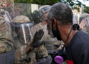 A man yells in the face of a soldier at sunrise outside the White House to protest the death in Minneapolis police custody of George Floyd in Washington, U.S., June 4, 2020.