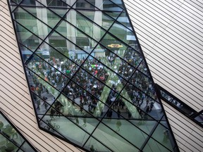 Protesters reflected in a building's windows march to highlight the death of Toronto's Regis Korchinski-Paquet on May 30, 2020.