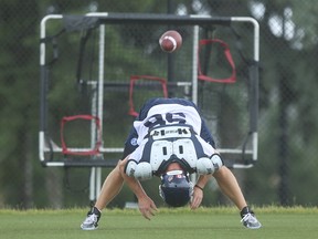 Argos ;long-snapper Jake Reinhart gets off some snaps on a practice net during a team practice.